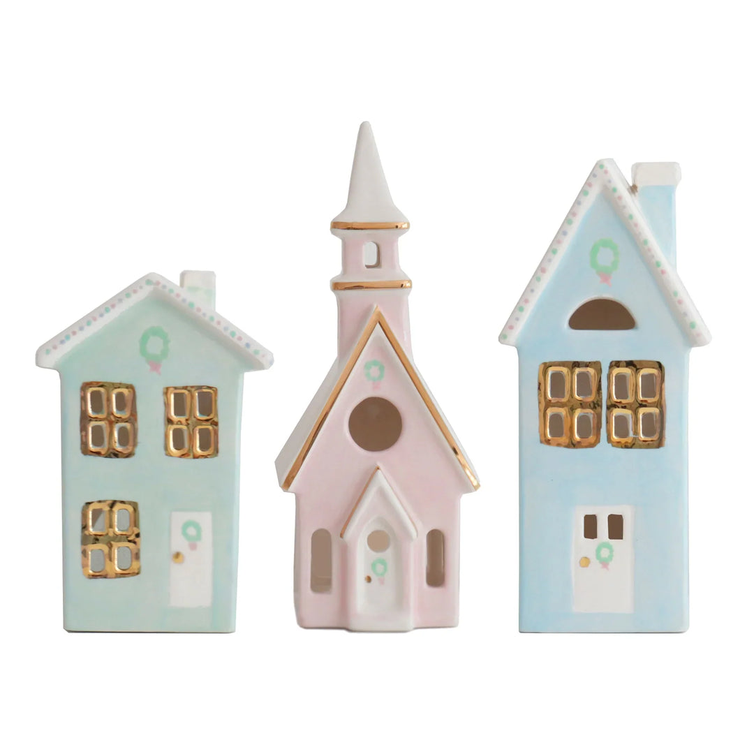 Set of three ceramic Christmas village, miniature house-shaped figurines  in pastel colors on a white background